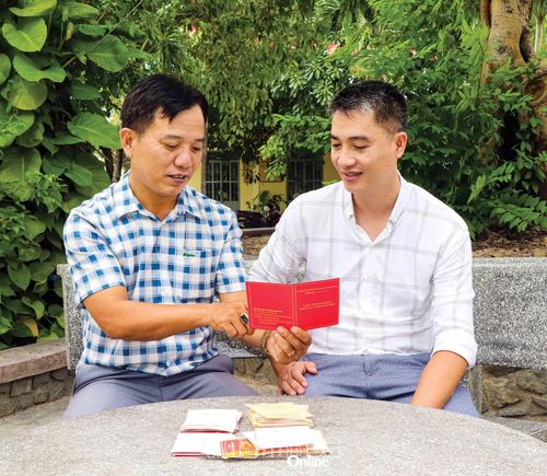 Ông Trần Kim Sơn (bên trái) chia sẻ với đồng nghiệp về những lần hiến máu tình nguyện của mình.