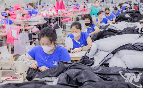 Cải thiện điều kiện làm việc và chế độ phúc lợi là giải pháp quan trọng để giữ chân người lao động. Trong ảnh: Công nhân sản xuất mặt hàng may xuất khẩu tại Công ty CP Đầu tư và Thương mại TNG.