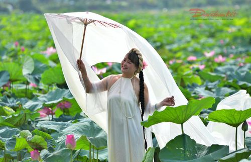 Một du khách đến đầm sen từ sớm để có được bộ ảnh kỷ niệm với sen.