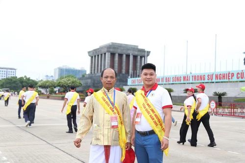Anh Phong (bên trái) mặc trang phục truyền thống của dân tộc Chăm tại Lễ báo công dâng Bác, trong chương trình Tôn vinh người hiến máu tình nguyện tiêu biểu toàn quốc năm 2026.
