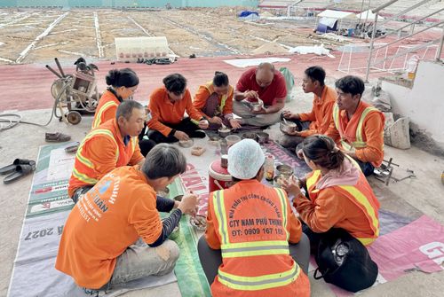 Các công nhân tranh thủ dùng bữa trưa ngay tại công trường