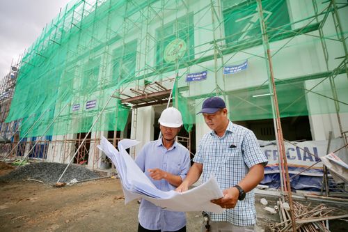 Ông Hoàng Ngọc Tuấn (phải), Phó Giám đốc Trung tâm TDTT Thống Nhất, đơn vị quản lý sân vận động Thống Nhất theo dõi tiến trình sửa chữa và màu sơn của mặt trước sân