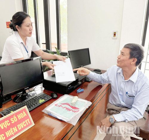 Cán bộ phường Nam Hoa Lư hướng dẫn thủ tục hành chính cho người dân. Ảnh: Nguyễn Hương