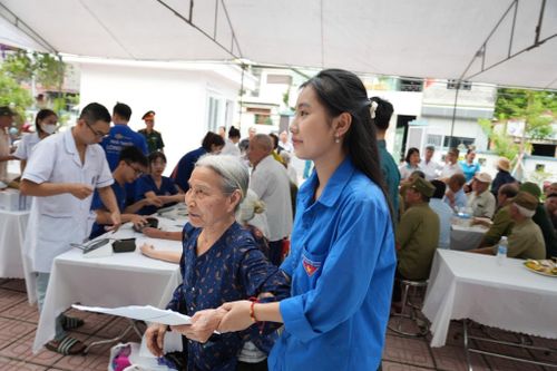 Đoàn viên, thanh niên hỗ trợ người có công đến vị trí thăm khám. Ảnh: Ngân Nguyễn