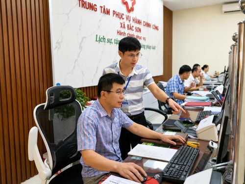 Ông Dương Việt Hùng (người đứng) hướng dẫn nhân viên Trung tâm Phục vụ Hành chính công xã Bắc Sơn thao tác nhập dữ liệu.