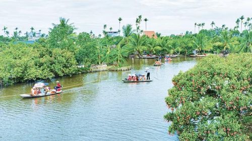 Chèo thuyền tham quan vườn vải tại Đồng Mẩn. (Ảnh: NHÂN CHÍNH)
