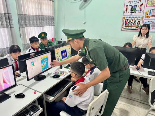 Cán bộ, chiến sĩ Đồn Biên phòng Xuân Đài hỗ trợ hướng dẫn học sinh tìm hiểu thư viên số.