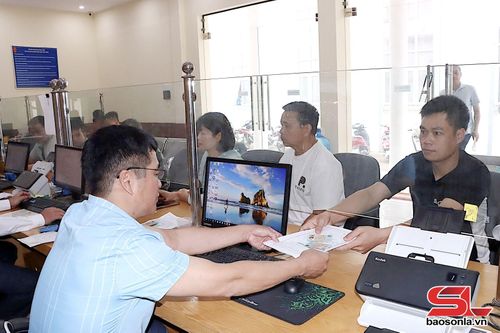 Cán bộ Trung tâm Phục vụ hành chính công xã Phù Yên trả kết quả giải quyết TTHC cho nhân dân.