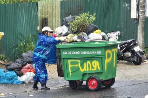 Công nhân Công ty Cổ phần Dịch vụ đô thị Đà Lạt đội mưa thu gom, vận chuyển rác thải sinh hoạt tại đường Pasteur, phường Xuân Hương - Đà Lạt