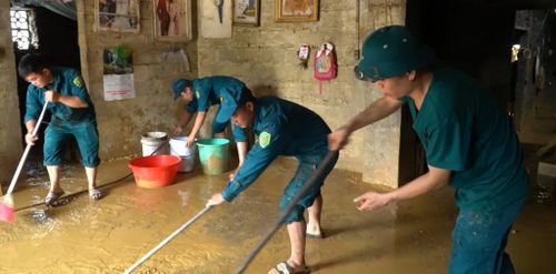 Lực lượng chức năng xã Lý Quốc hỗ trợ người dân khắc phục hậu quả mưa lũ.