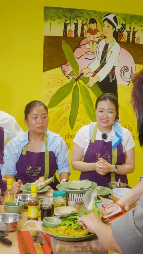 Phan Hoàng Kim - chủ kênh Ahihi Peekaboo và Nguyễn Ánh Xuân - chủ kênh Xuân Nghi đi chơi cùng chăm chú nghe chuyên gia ẩm thực chia sẻ, trước khi bắt tay vào thực hành làm các món bánh xèo, gỏi cuốn.