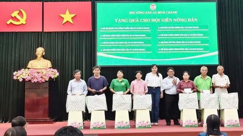 Hội Nông dân xã Bình Chánh và Công ty Trách nhiệm hữu hạn một thành viên Thực phẩm Quốc Thịnh tặng quà các hộ nông dân cận nghèo.