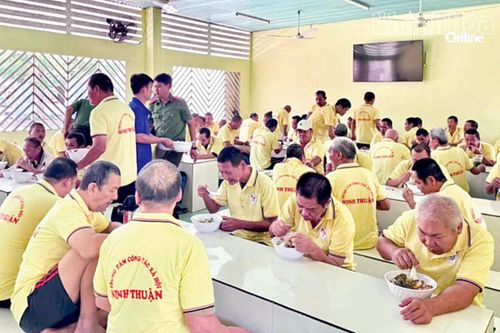 Người khuyết tật thần kinh, tâm thần vui vẻ dùng bữa trong chương trình thiện nguyện do Công an xã Mỹ Sơn tổ chức.