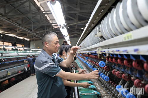 Ông Trần Văn Ba, Giám đốc Công ty TNHH Tơ lụa Hualong Lâm Đồng kiểm tra chất lượng tơ tại nhà máy.