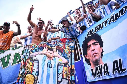 Các cổ động viên Argentina mang theo những lá cờ khổ lớn in hình Messi và cố huyền thoại Diego Maradona. Những biểu ngữ này được giăng kín khán đài, như sự kết nối giữa hai thế hệ biểu tượng vĩ đại nhất lịch sử bóng đá Argentina. Trong ngày Messi lập hat-trick và cân bằng kỷ lục ghi bàn tại World Cup, khán đài Kansas thực sự trở thành một lễ hội tôn vinh huyền thoại sống của bóng đá thế giới.