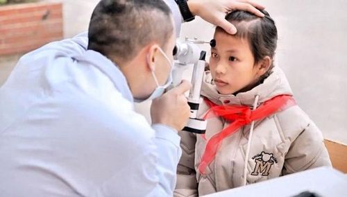 Bác sĩ khám mắt cho học sinh