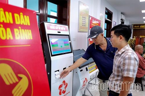 Để nâng cao chất lượng phục vụ người dân, cán bộ Trung tâm Phục vụ hành chính công phường Hòa Bình bố trí cán bộ hướng dẫn người dân lấy số thứ tự để thực hiện giao dịch hành chính.