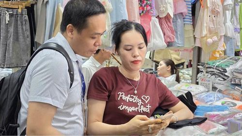 Cán bộ VNPT Huế hướng dẫn tiểu thương chợ Đông Ba thao tác thanh toán