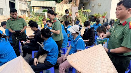 Công an phường Phú Lợi phát tờ rơi, hướng dẫn cài phần mềm "SOS An ninh trật tự" cho công nhân.