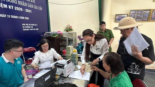 Người dân xã Thường Tín đối chiếu các thông tin trước khi nhận tiền chi trả, bồi thường giải phóng mặt bằng dự án xây dựng Khu đô thị thể thao Quốc tế Hà Nội. Ảnh: PV