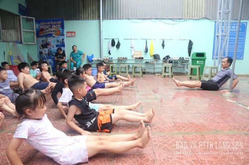 Giáo viên hướng dẫn học viên kỹ thuật bơi trước khi thực hành bơi dưới nước