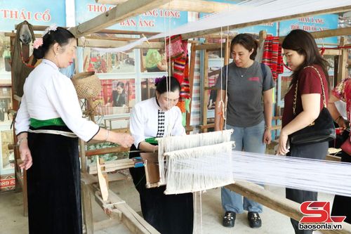 Du khách tham quan dệt vải truyền thống của đồng bào Thái phường Mộc Sơn.