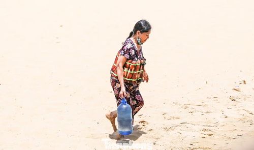 Không chỉ tắm biển, nhiều người còn mang theo can nhựa, chai lọ để lấy nước biển đem về cho người thân không có điều kiện ra biển tắm.