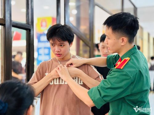 Thí sinh tháo vòng cổ, vòng tay trước khi vào điểm kiểm tra an ninh. Ảnh: Thúy Nga