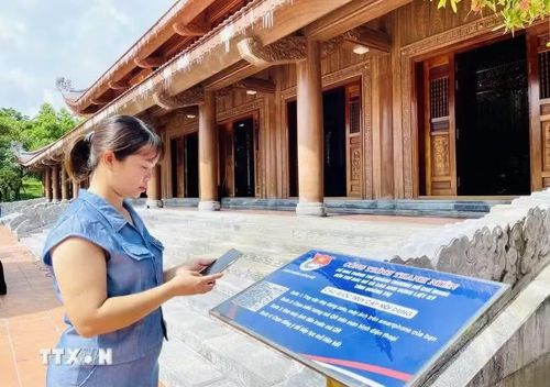 Người dân trải nghiệm quét mã QR tìm hiểu thông tin ở Công trình thanh niên số hóa Quảng trường Hồ Chí Minh-Đền thờ Bác Hồ và các anh hùng liệt sỹ (phường Đồng Hới, tỉnh Quảng Trị). (Ảnh: TTXVN)