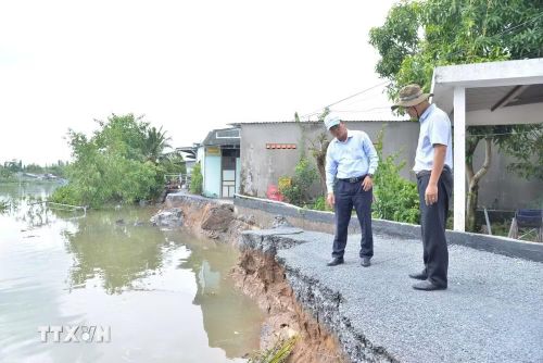 Lãnh đạo Sở Nông nghiệp và Môi trường tỉnh Đồng Tháp khảo sát hiện trường vụ sạt lở. (Ảnh: Công Trí/TTXVN)