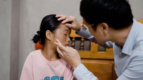 Bác sĩ Tâm khám cho em Lý Thị Yến (SN 2012, quê Văn Bàn, Lào Cai cũ), em nhỏ mắc bớt Ota sắc tố nâu đậm vùng trung tâm mặt.