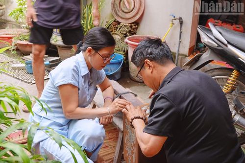 Ông Hải cùng vợ đang hoàn thiện nốt những công đoạn cuối cùng của sản phẩm. (Ảnh: HÀ THƯƠNG)