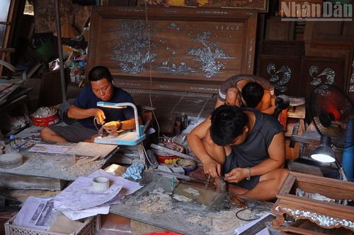 Những người thợ miệt mài, tỉ mẩn trong căn xưởng nhỏ của ông Hải. (Ảnh: HÀ THƯƠNG)