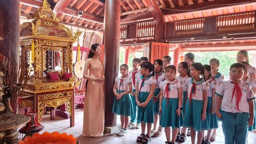 Học sinh xã Sơn Cẩm Hà được nghe cô giáo giới thiệu về lịch sử Đình làng Hội An.