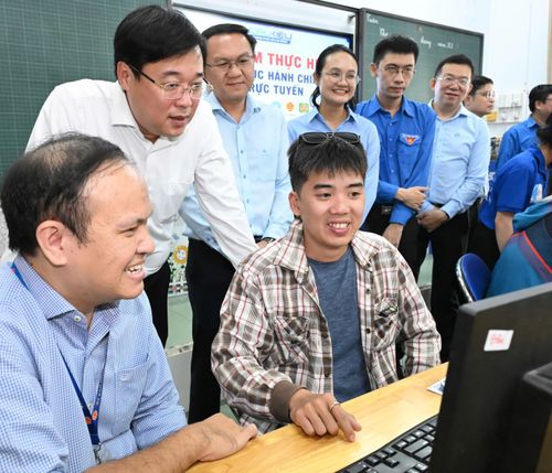  Đồng chí Lê Quốc Phong trò chuyện cùng các lực lượng tổ công nghệ số cộng đồng tại điểm Trường Tiểu học Đông Ba. Ảnh: VIỆT DŨNG 