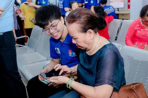 Thanh niên hướng dẫn người dân sử dụng đăng nhập nền tảng số.