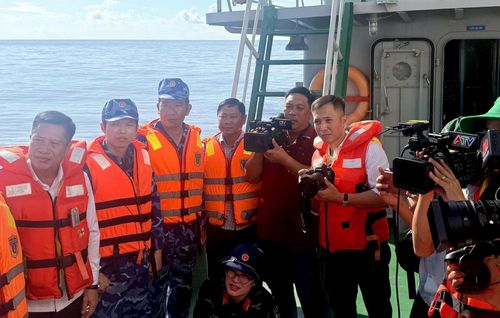 Việc tiếp cận tàu cá để ghi lại hoạt động của Đoàn công tác đòi hỏi phóng viên vừa bảo vệ thiết bị tác nghiệp vừa chờ đúng nhịp sóng để lên tàu an toàn.