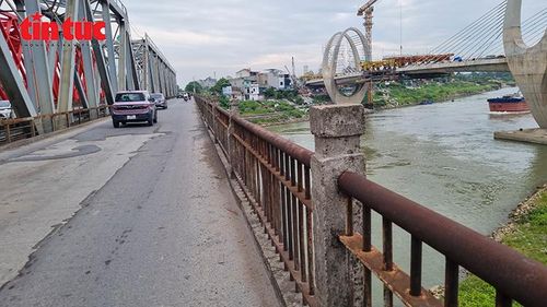 Lan can cầu Đuống cũ hoen gỉ, xuống cấp sau hơn một thế kỷ khai thác, đối lập với diện mạo hiện đại của cầu Đuống mới đang xây dựng phía hạ lưu.