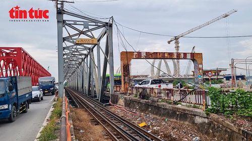 Cầu Đuống cũ hiện có hệ thống đường sắt chạy giữa cầu, hai bên là làn phương tiện đường bộ; phía xa là công trường cầu Đuống mới.