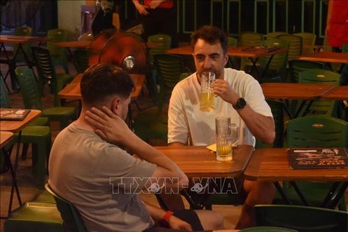 Du khách thưởng thức bia trên phố Tạ Hiện (Hà Nội). Ảnh: Tuyết Mai/TTXVN