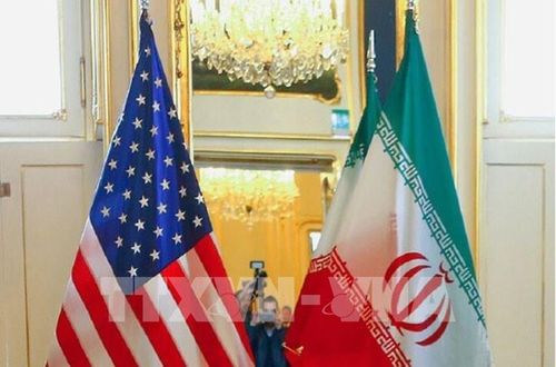 Quốc kỳ Mỹ (trái) và Iran tại một bàn đàm phán. Ảnh: MNA/TTXVN