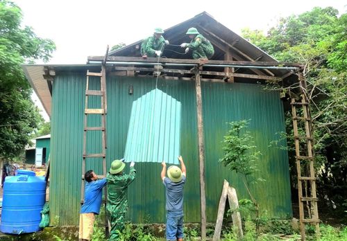 Cán bộ, chiến sĩ Đồn Biên phòng Cà Xèng giúp dân sửa chữa, làm nhà mới - Ảnh: T.L