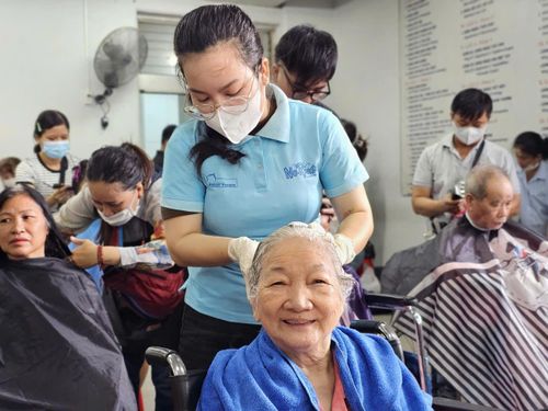  Bà Năm vừa nghe ca nhạc vừa được gội đầu. Ảnh: Nguyễn Thuận. 