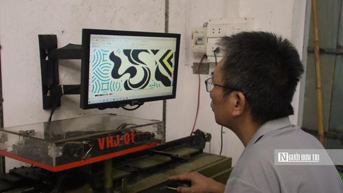 Nghệ nhân Đỗ Văn Hiển vẽ hoa văn trên máy tính.