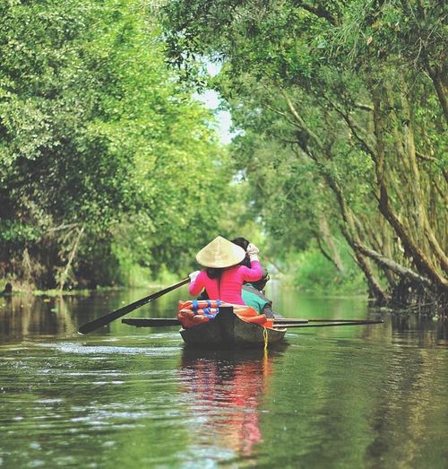 Du khách ngồi thuyền ngắm nhìn cảnh quan sông nước
