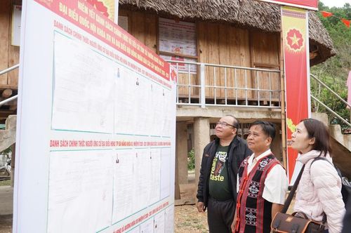 Tác giả cùng người dân thôn R’Cung (xã biên giới A Vương) tại điểmniêm yết người ứng cử Đại biểu HĐND xã A Vương nhiệm kỳ 2026 – 2031. Ảnh: Bình An