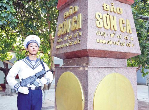 Chiến sĩ trên đảo Sơn Ca đứng gác bên cột mốc chủ quyền.