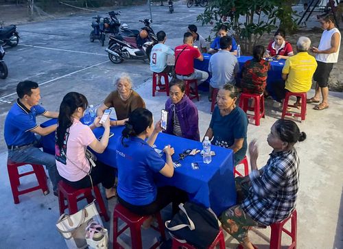 Các tổ công nghệ số cộng đồng của phường Bàn Thạch hướng dẫn người dân thực hiện các thủ tục hành chính vào ban đêm. Ảnh: HỒ QUÂN