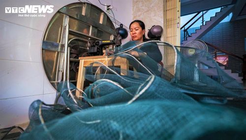 Tranh thủ thời gian rảnh, phụ nữ làng chài lại may vá lưới cho kịp chồng, con đi chuyến biển mới.