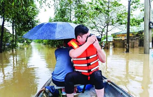 Phóng viên tác nghiệp tại điểm ngập lụt chợ Phong Mỹ chiều 18/11/2025. Ảnh: Hoàng Dũng.